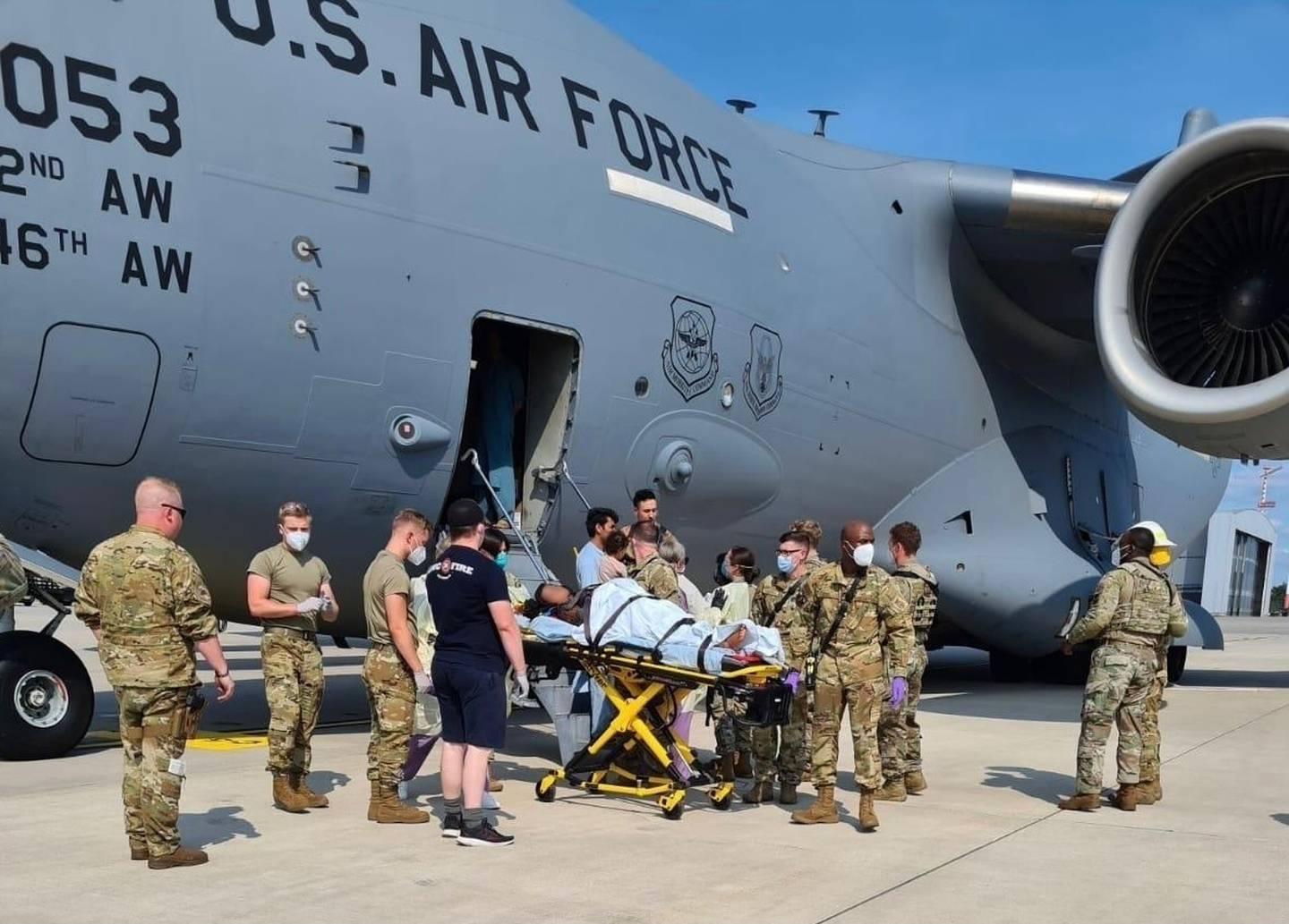 Medical support personnel from the 86th Medical Group and Landstuhl Regional Medical Center help an Afghan mother and family off a U.S. Air Force C-17, call sign Reach 828, moments after she delivered a child aboard the ai Afghan baby born on C-17 bound for Germany named ‘Reach,’ after the jet’s call sign
