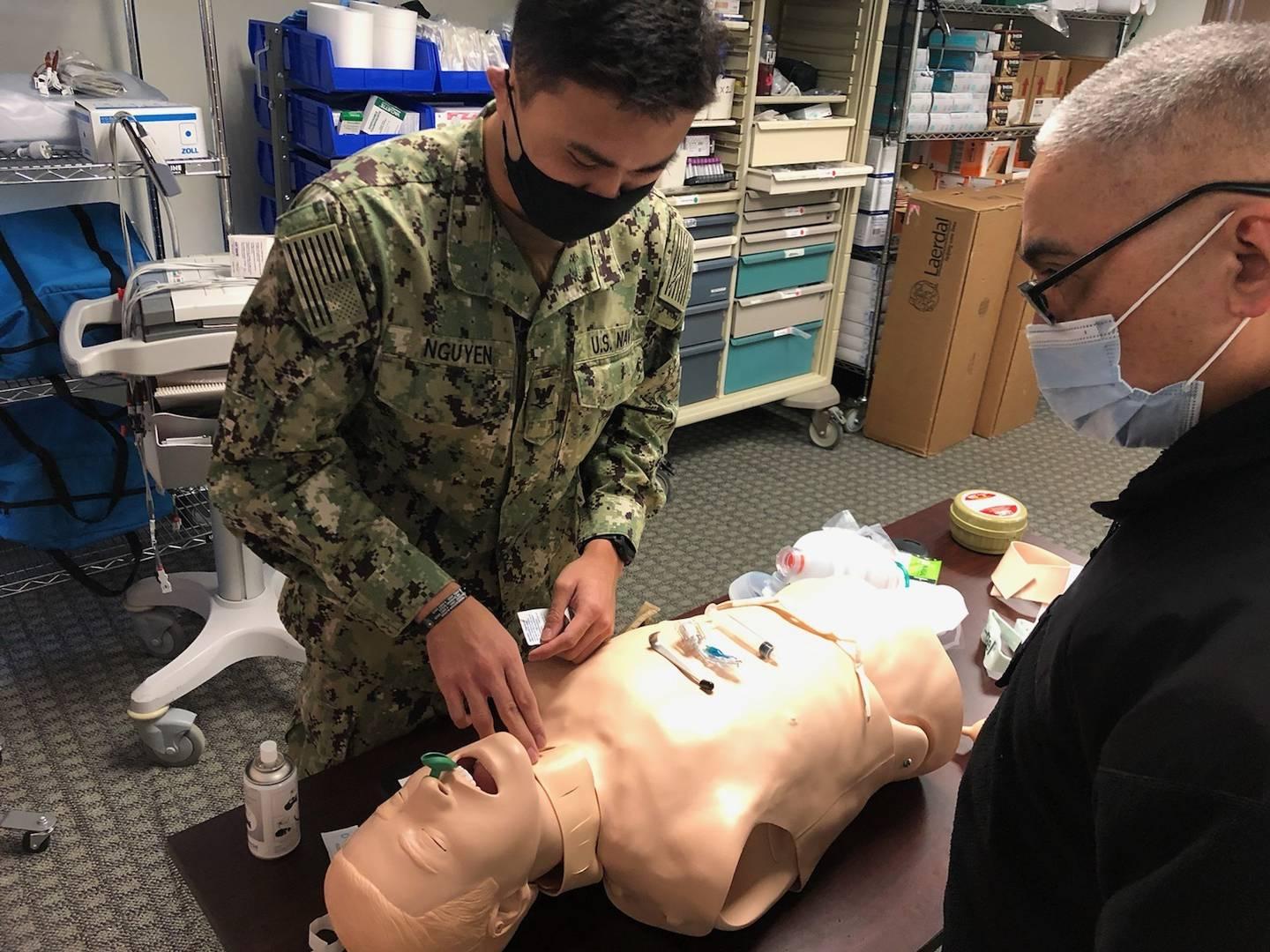 Hospital Corpsman 3rd Class Anson Nguyen, a Hospital Corpsman Trauma Training-Great Lakes, Ill., student, prepares to perform a cricothyrotomy on a training manikin. (Cmdr. Colleen Abuzeid/Navy) (Navy Medicine Operational 