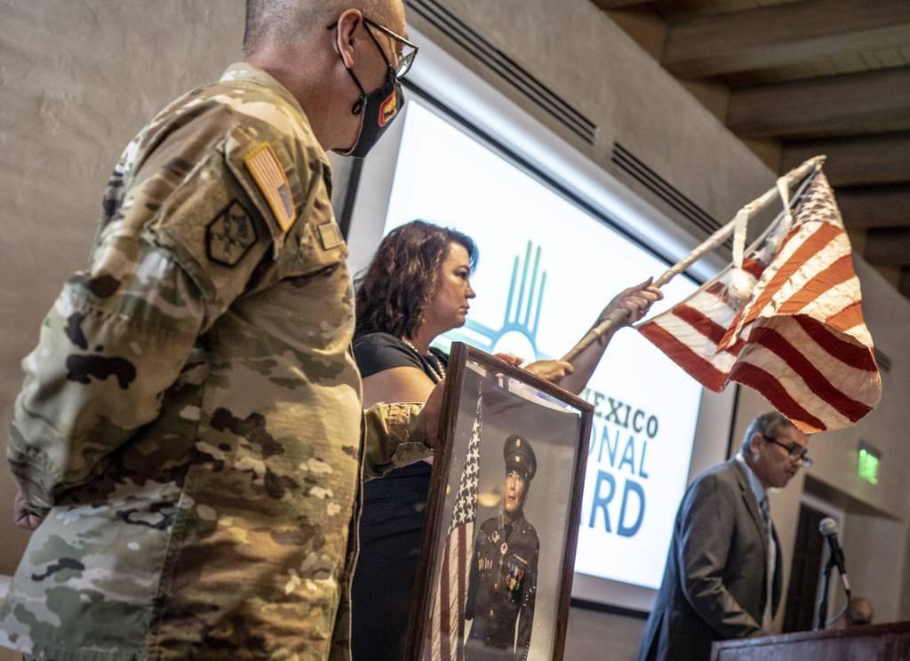 Retired Col. Brian Baca, right, tells New Mexico National Guard soldiers and airmen the incredible story of an American flag made from scraps of material in a Japanese prisoner of war camp during World War II, Wednesday, S