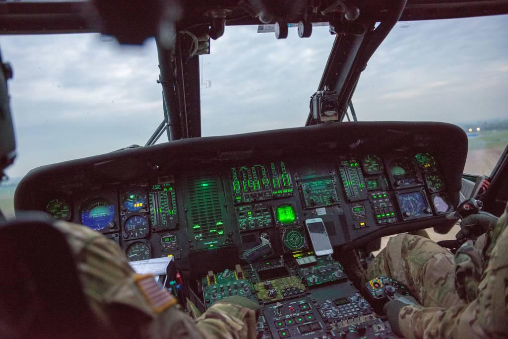 The cockpit of a U.S. Army UH-60-L Black Hawk helicopter of the 3rd Combat Aviation Brigade, 3rd Infantry Division, is lit, over Chièvres Air Base, Belgium, Oct. 23, 2019. (Pierre-Etienne Courtejoie/Army) Army Black Hawk pilot builds tool to improve flight training, wins competition