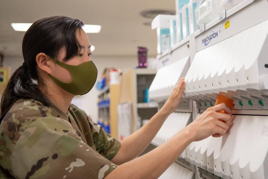 Tech. Sgt. Hannah Harris, 18th Medical Support Squadron registered pharmacy technician, fills a prescription bottle from a pill-counting machine at Kadena Air Base, Japan, July 8. (Airman 1st Class Yosselin Perla/Air Force Despite drug shortages, military has mostly been able to find alternative supplies
