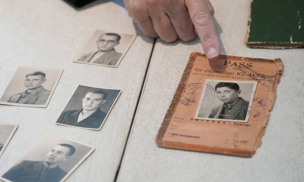 Anna Salton Eisen, daughter of Holocaust survivors, points to a photo of her father, George Lucius Salton, made along with another photo he saved after his internment in Nazi work camps, during an interview in Westlake, Te Veteranâ€™s daughter meets with descendants of Holocaust survivors freed with her dad