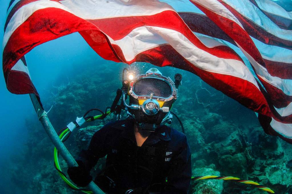 Jules McManus waves the flag over a found WWII MIA B-24 during recovery operations in 2008 in Palau. (Chris Perez/Courtesy of Abramorama) Documentary chronicles efforts to repatriate American service members missing since WWII