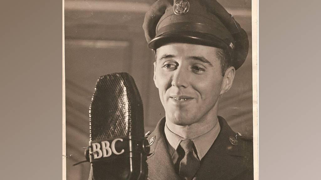In this World War II-era photograph provided by the Defense POW/MIA Accounting Agency, Army Air Forces Staff Sgt. Charles G. McMackin, of Revere, Mass., stands in front of a microphone. (Defense POW/MIA Accounting Agency v US airman shot down over Romania in WWII is accounted for