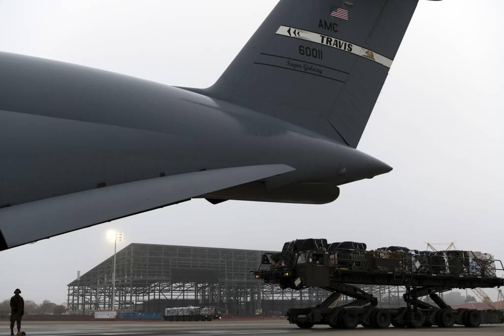 Water and other cargo on a K-loader approaches a C-5M Super Galaxy Dec. 5, 2021, at Travis Air Force Base, California. (Senior Airman Jonathon Carnell/Air Force) Travis AFB airmen bring water to military families in Hawaii amid water crisis