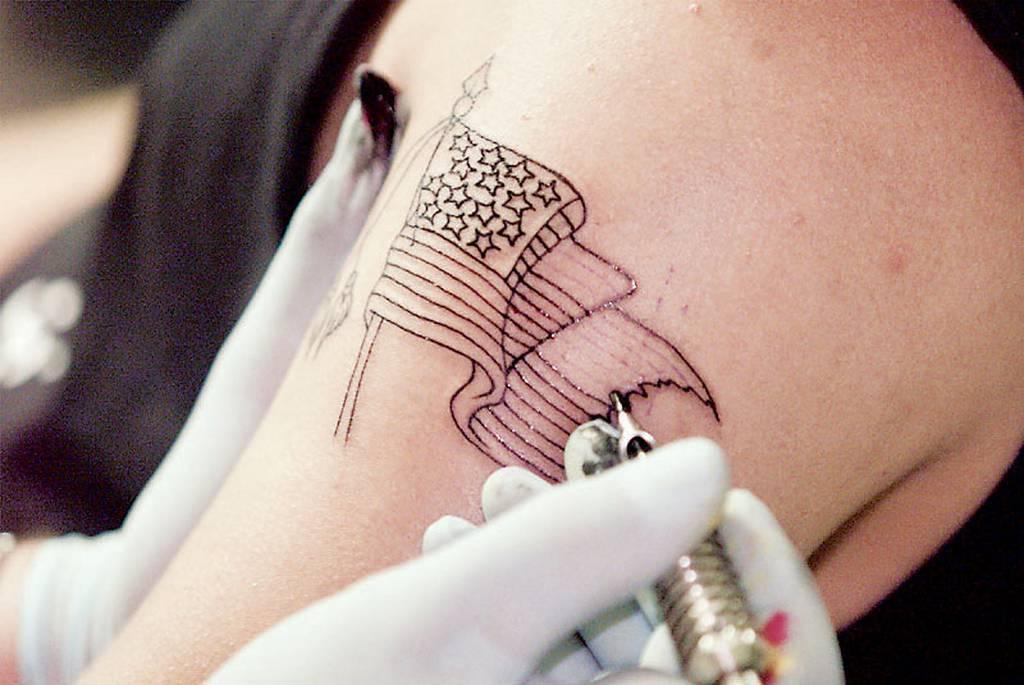 Marine Cpl. Jeremy Carter gets a tattoo of a American Flag on his arm on Thursday, Sept. 20, 2001, from tattoo artist Lee Waters of Tattoo Lee's Golden Needle in Jacksonville, North Carolina, the home of Camp Lejeune Marin New in 2022: Marine Corps loosens its strict tattoo policy