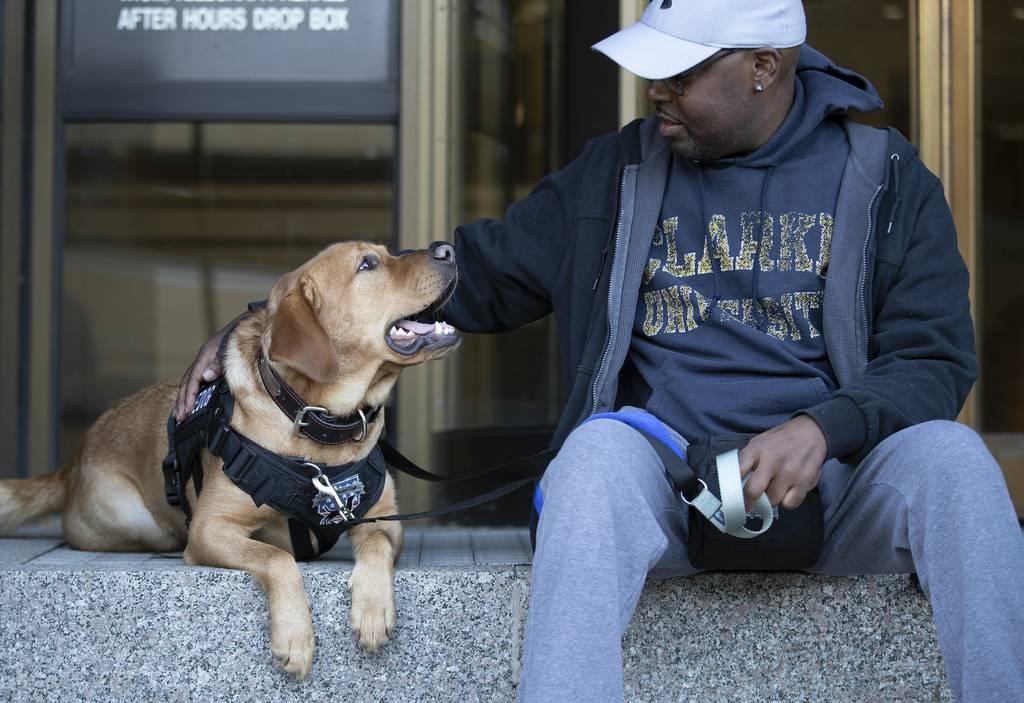 Garland Shirley pets his service dog, Smitty, in downtown Dubuque, Iowa, on Thursday, Dec. 16, 2021. (Stephen Gassman/Telegraph Herald via AP) Service dogs help Iowa veterans, first responders