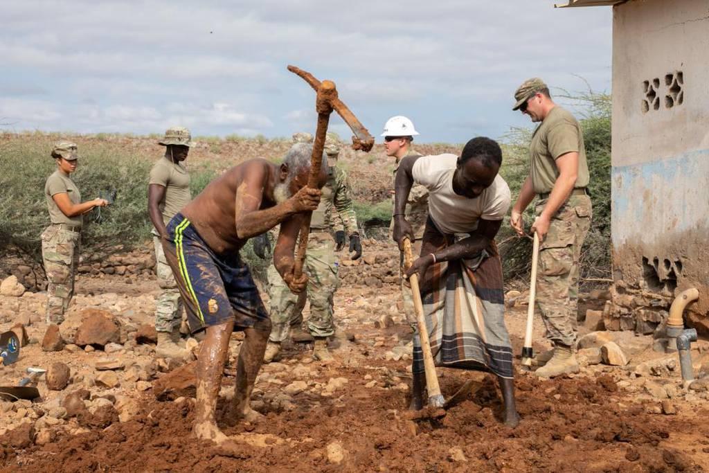 Djiboutians and U.S. soldiers dig out a broken pipe during a well leak repair at Chabelley Village, Djibouti, Dec. 22, 2021. (Spec. Gauret Stearns/Army) US soldiers help fix the only well in Djiboutian village