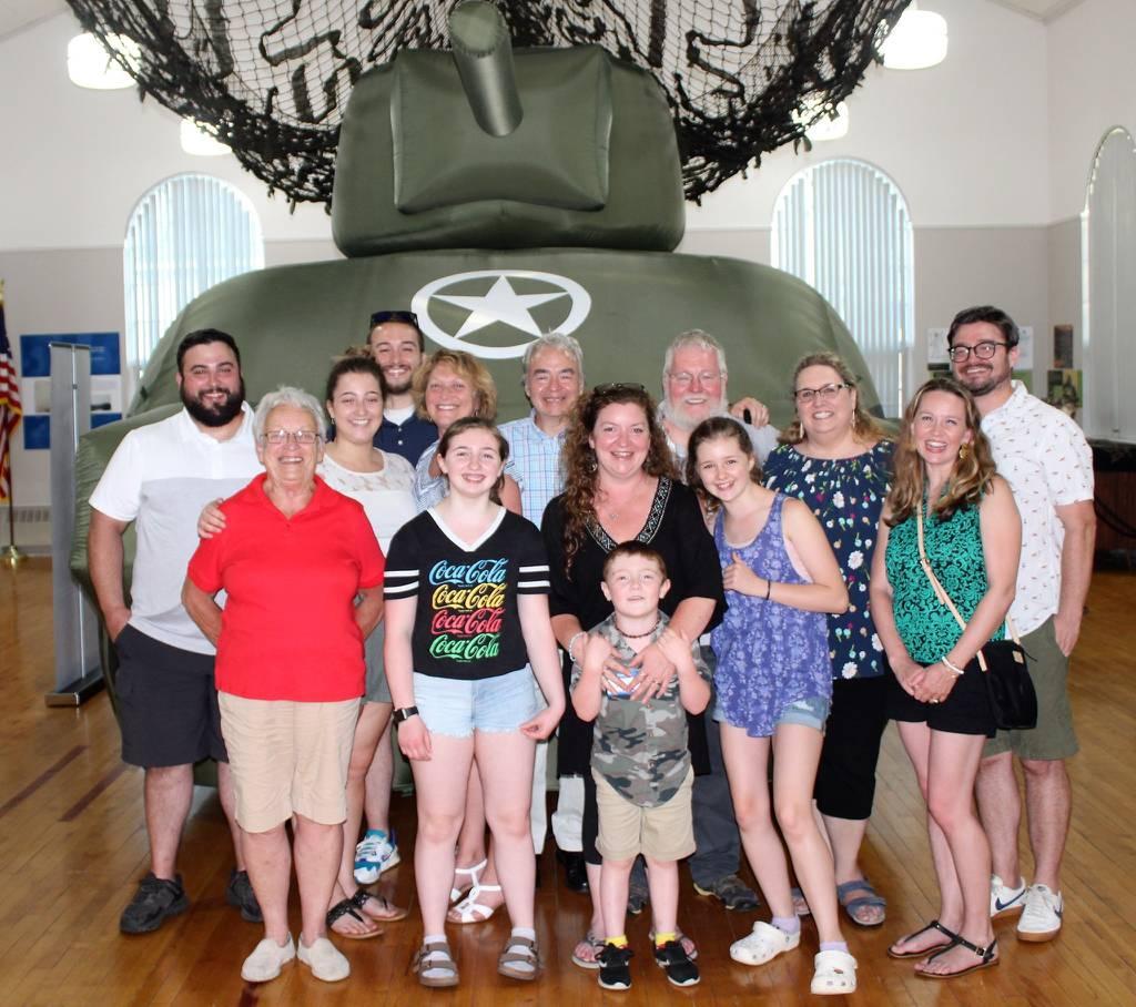 This photo provided by Andrea J. Cheeney shows four generations of the McKane family pose with an inflatable tank at the Ghost Army exhibit on June 7, 2021 at Historical Society of Cheshire County, Keene N.H. Their patriar WWII â€˜Ghost Armyâ€™ members to be awarded Congressional Gold Medal