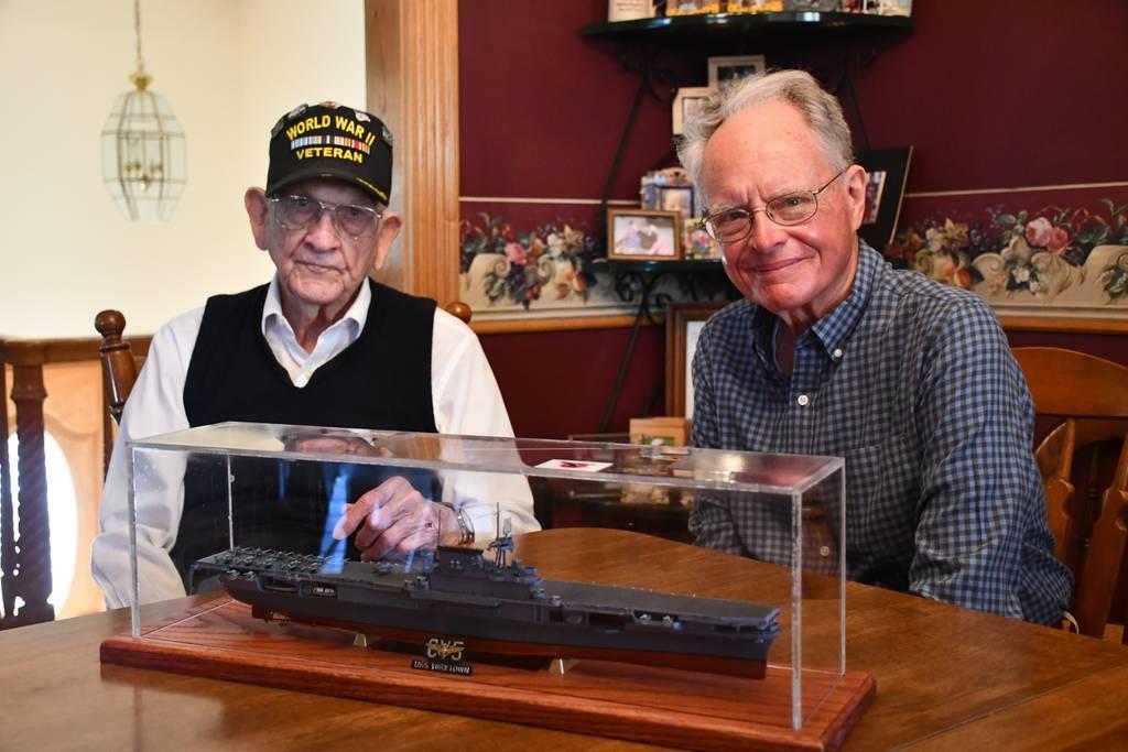 Julian Hodges, left, and David Denny, right, pose with a replica model of the USS Yorktown built by Denny. Hodges served aboard the USS Yorktown during the Battle of Midway in 1942. (Kayla Hackney/The Johnson City Press vi