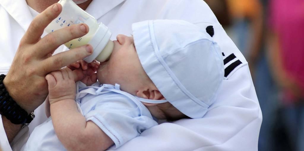Sonar Technician (Surface) 2nd Class Cameron Webster feeds his baby one last time before boarding the guided-missile destroyer Farragut to go on deployment in January 2018. (MC3 A.J. Jones/Navy) Navy adds seven days to secondary caregiver leave
