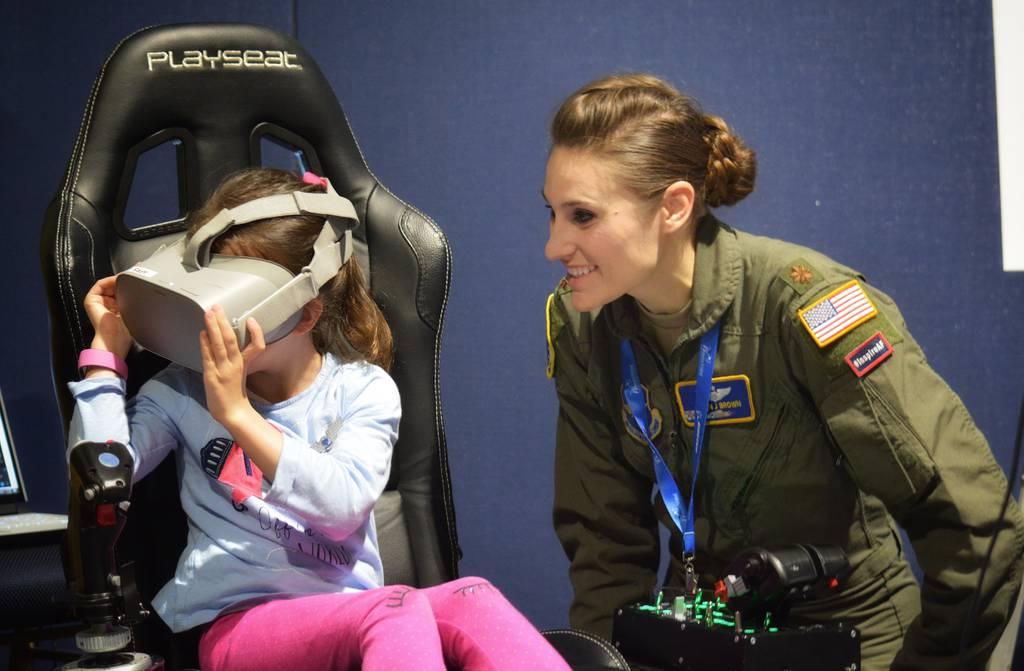 Maj. Afton Brown, Air Force Recruiting Service Detachment 1, assists a young aviator during the Girls in Aviation Day at the Women in Aviation International conference in Lake Buena Vista, Fla., March 7, 2020. (Christa Dâ€ Air Force reviewing gender-biased policies affecting airmen, guardians