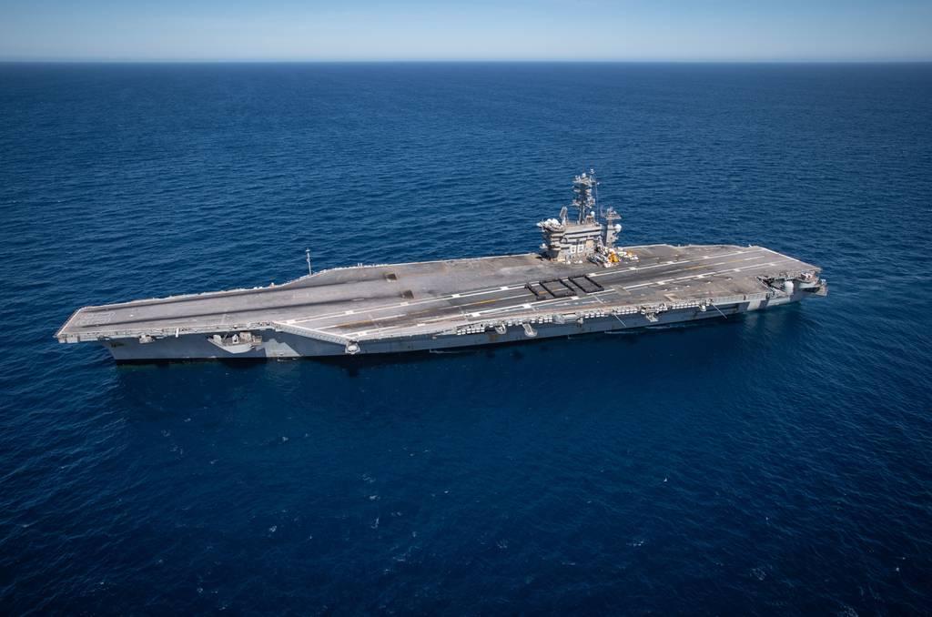 Sailors aboard the aircraft carrier Nimitz assemble on the flight deck and form a human 