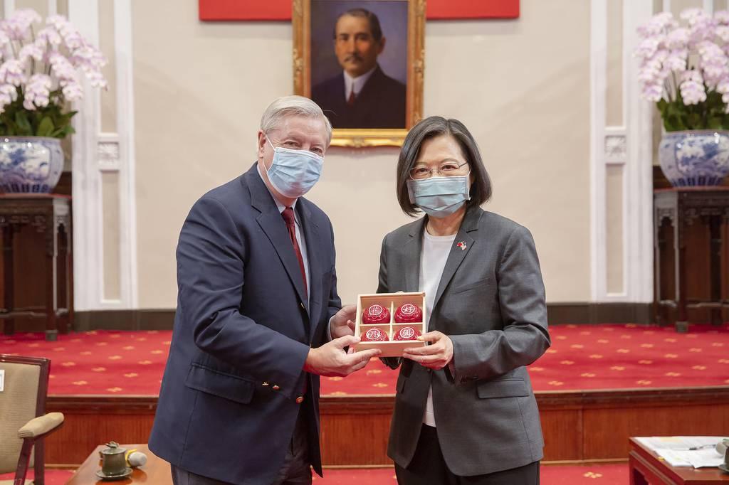 Sen. Lindsey Graham, R-S.C., left, and Taiwan's President Tsai Ing-wen, right, pose for a photo during a meeting at the Presidential Office in Taipei, Taiwan, Friday, April 15, 2022. (Taiwan Presidential Office via AP) China stages military exercises as US lawmakers visit Taiwan