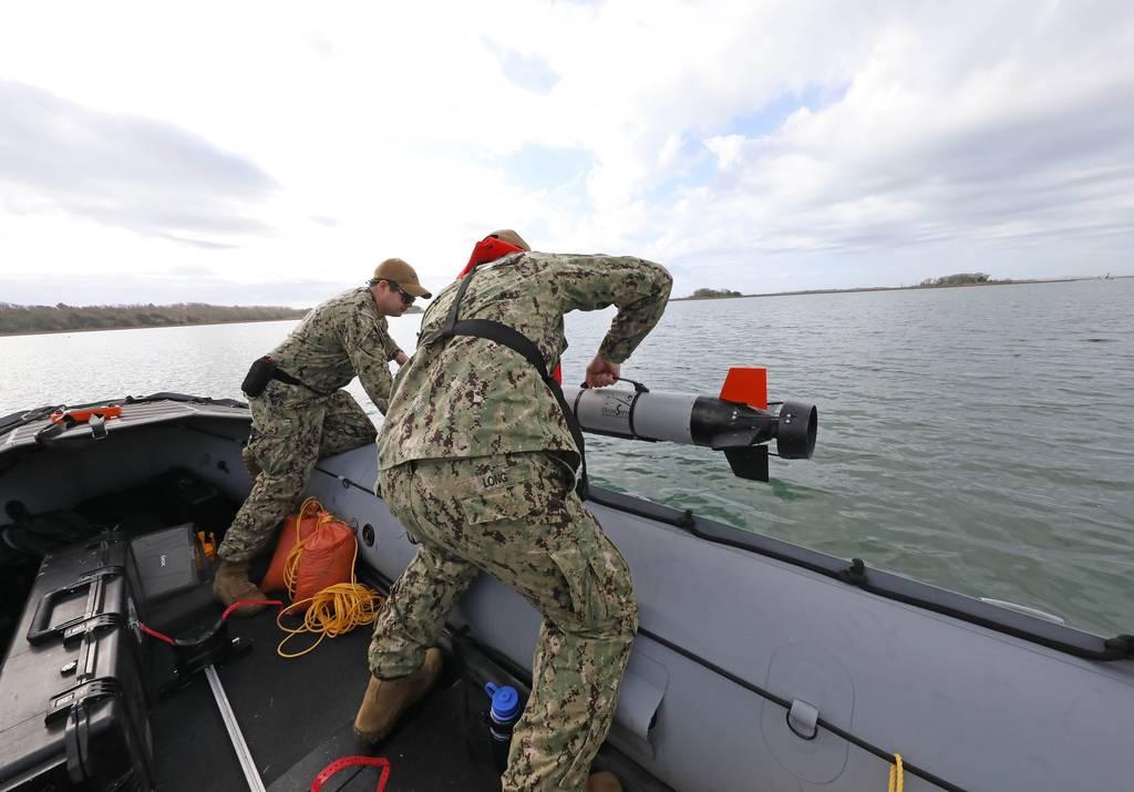 Torpedoman 1st Class Corey Hill and Chief Electronics Technician Daniel Long, assigned to Unmanned Undersea Vehicle Squadron 1, launch the IVER3 Autonomous Underwater Vehicle off the coast of Camp LeJeune, N.C., on March 2 Navy, Marines integrating expeditionary forces into traditional amphibious operations