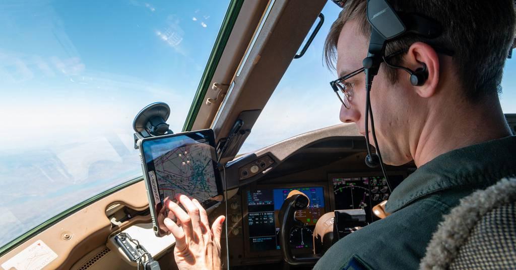 Captain Taylor Johnson, 349th Air Refueling Squadron instructor pilot, checks flight path details May 5. He is able to see live updates of weather, air traffic and flight plans using a Stratus puck. (Airman Brenden Beezley