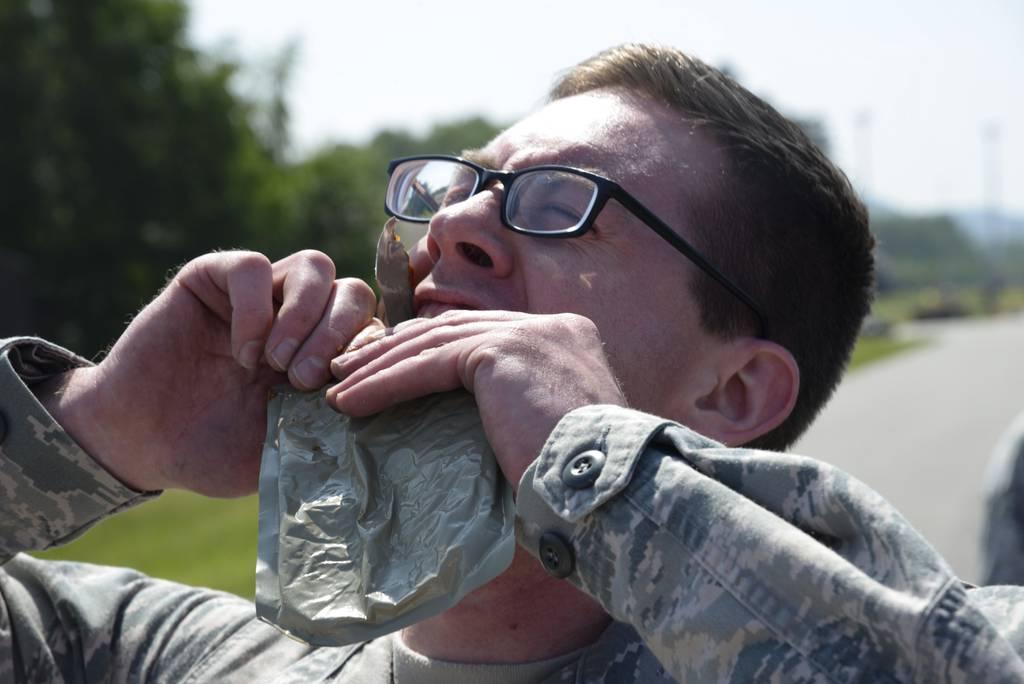 Atlantic Stripe Conference participants devour Meals Ready-to-Eat, also known as MREs, during an obstacle course on Ramstein Air Base, in Germany. (Airman 1st Class D. Blake Browning/Air Force)