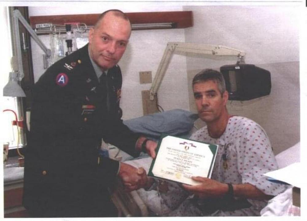 Enlarge Purple Heart recipient Army Sgt. 1st Class Joe Bowser receiving his award from his hosp... 